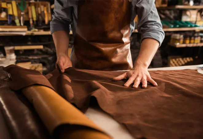 close up cobbler working with leather textile scaled