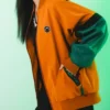 Close-up of Melinoë Model Hades II Blouson Orange And Green Jacket