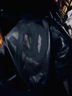 Close view of StupidDOPE x The Weeknd XO logo Black Leather Varsity Bomber Jacket
